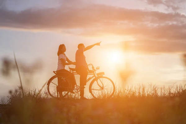 自転車の愛幸せな時間で甘いの若いカップルのシルエット — ストック写真