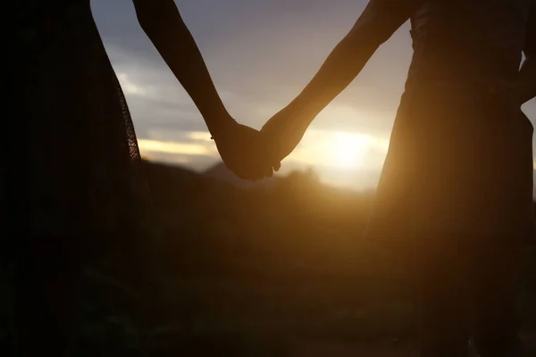 young couple holding hands. In Nature sunrise
