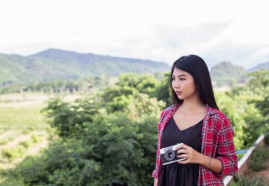 Vintage Fotoğraf makinesinin güzel kadınlar fotoğraf ayakta el holding retro gündoğumu, rüya yumuşak tarzı ile