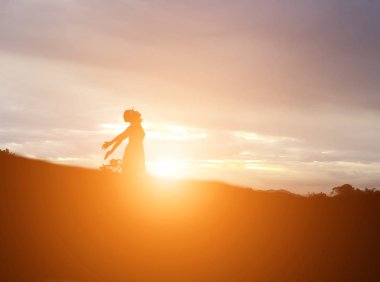 Güzel bir arka plan için dua eden bir kadın silueti.