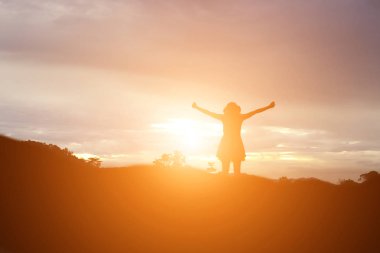 Güzel bir arka plan için dua eden bir kadın silueti.