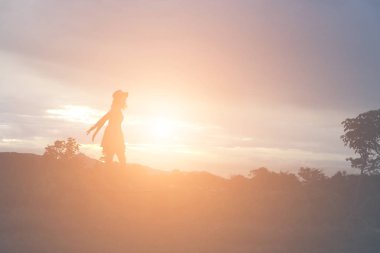 Güzel bir arka plan için dua eden bir kadın silueti.