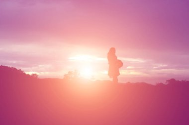 Güzel bir arka plan için dua eden bir kadın silueti.