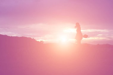 Güzel bir arka plan için dua eden bir kadın silueti.