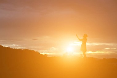 Güzel bir arka plan için dua eden bir kadın silueti.