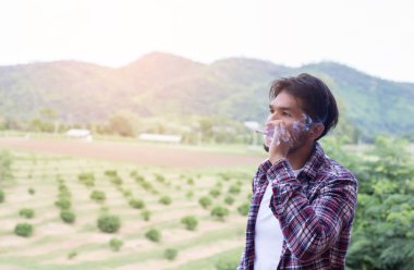 Hipster adam duman sigara, bir dağın duruyor. Sabah temiz havada arasında.