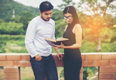Dizüstü bilgisayarda yazarak ve kitap okuma genç eğitim uygulama birlikte el.