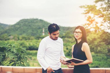 Dizüstü bilgisayarda yazarak ve kitap okuma genç eğitim uygulama birlikte el.