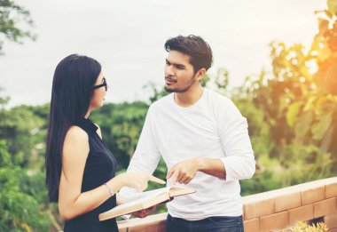 Dizüstü bilgisayarda yazarak ve kitap okuma genç eğitim uygulama birlikte el.