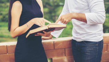 Dizüstü bilgisayarda yazarak ve kitap okuma genç eğitim uygulama birlikte el.