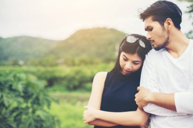 Genç yakışıklı erkek arkadaşı, sarılma o üzgün ve kızgın.