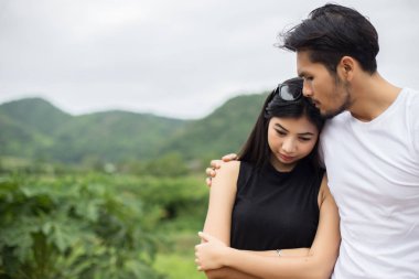 Genç yakışıklı erkek arkadaşı, sarılma o üzgün ve kızgın.