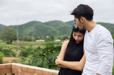 Genç yakışıklı erkek arkadaşı, sarılma o üzgün ve kızgın.