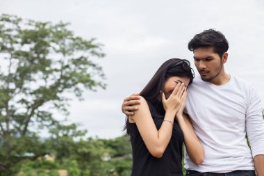 Genç yakışıklı erkek arkadaşı, sarılma o üzgün ve kızgın.