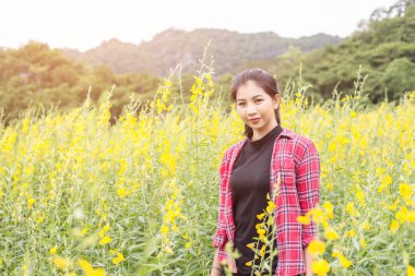 Çiçek alan zevk içinde duran genç güzel kadın.