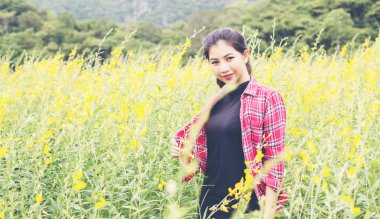 Çiçek alan zevk içinde duran genç güzel kadın.