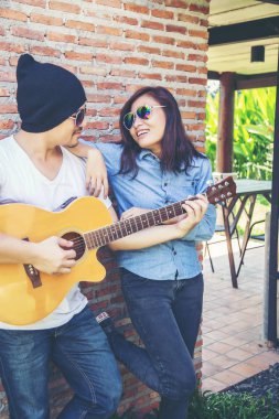 Genç hipster adam onun tatile rahatlatıcı için gitar çalmak zevk ile doğal ve taze hava.