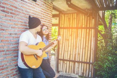 Genç hipster adam onun tatile rahatlatıcı için gitar çalmak zevk ile doğal ve taze hava.