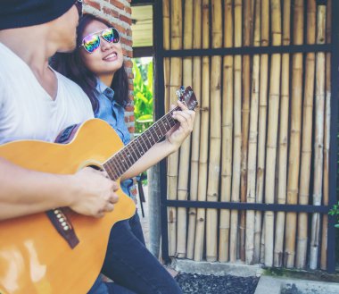 Genç hipster adam onun tatile rahatlatıcı için gitar çalmak zevk ile doğal ve taze hava.
