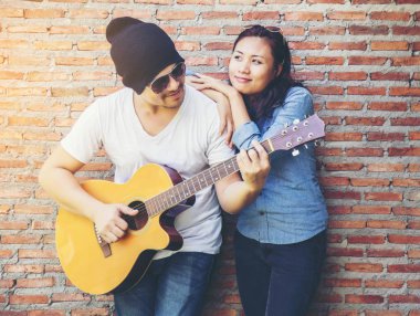 Genç hipster adam onun tatile rahatlatıcı için gitar çalmak zevk ile doğal ve taze hava.