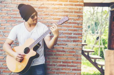 Genç hipster adam onun tatile rahatlatıcı için gitar çalmak zevk ile doğal ve taze hava.