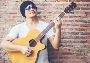 Genç hipster adam onun tatile rahatlatıcı için gitar çalmak zevk ile doğal ve taze hava.