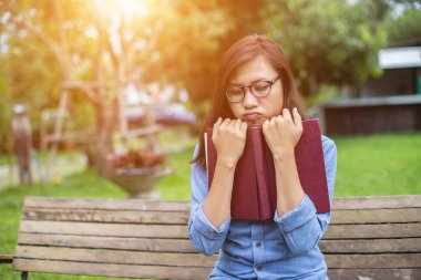 Bir kitap okuma bahçede oturan bir kadın.
