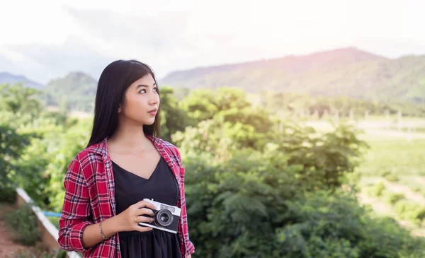 Vintage of beautiful women photography standing hand holding retro camera with sunrise,dream soft style