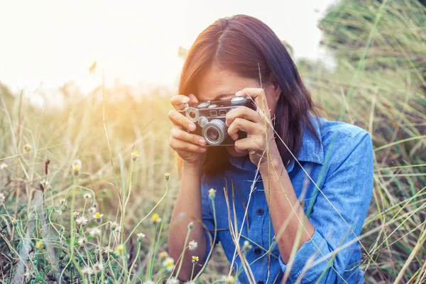 Vintage of beautiful women photography standing hand holding retro camera with sunrise,dream soft style