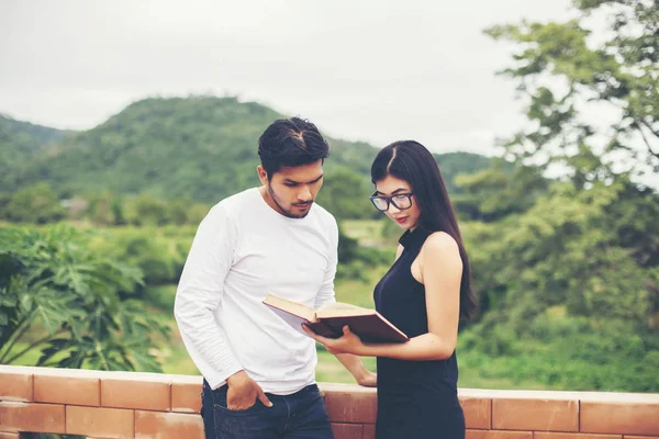 Dizüstü bilgisayarda yazarak ve kitap okuma genç eğitim uygulama birlikte el.