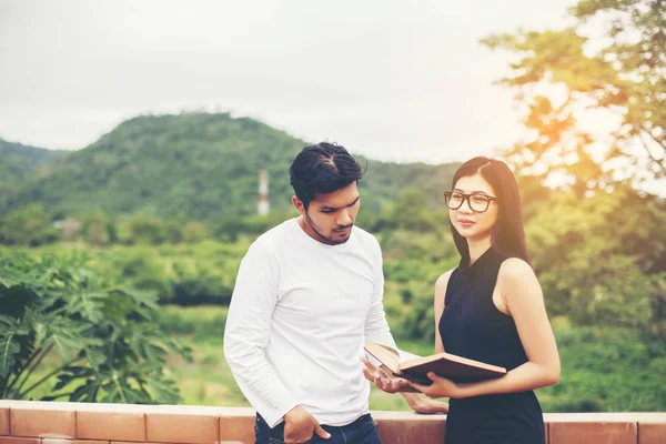 Dizüstü bilgisayarda yazarak ve kitap okuma genç eğitim uygulama birlikte el.