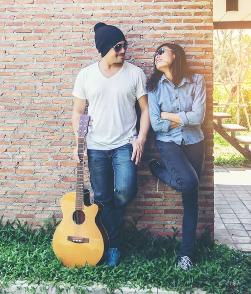 Genç hipster adam onun tatile rahatlatıcı için gitar çalmak zevk ile doğal ve taze hava.