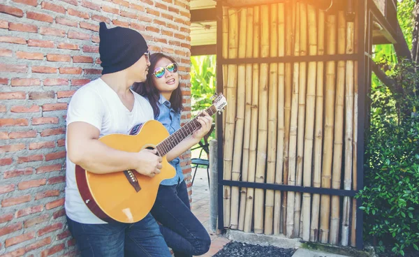 Genç hipster adam onun tatile rahatlatıcı için gitar çalmak zevk ile doğal ve taze hava.