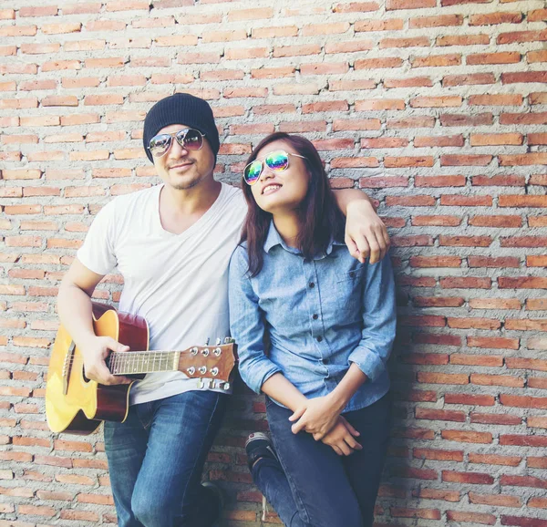 Genç hipster adam onun tatile rahatlatıcı için gitar çalmak zevk ile doğal ve taze hava.