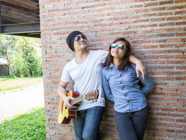 Genç hipster adam onun tatile rahatlatıcı için gitar çalmak zevk ile doğal ve taze hava.