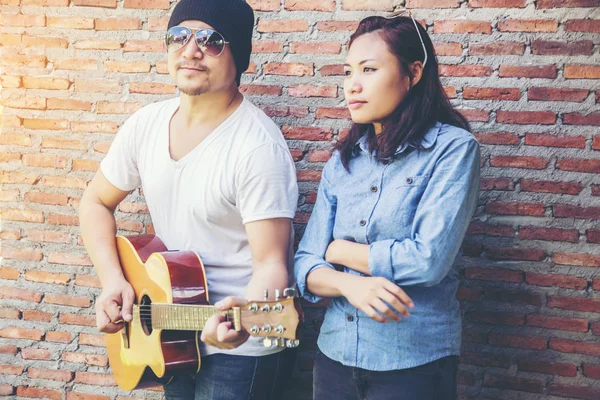 Genç hipster adam onun tatile rahatlatıcı için gitar çalmak zevk ile doğal ve taze hava.