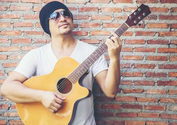 Genç hipster adam onun tatile rahatlatıcı için gitar çalmak zevk ile doğal ve taze hava.