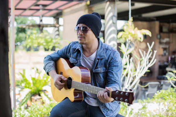 Genç hipster adam onun tatile rahatlatıcı için gitar çalmak zevk ile doğal ve taze hava.