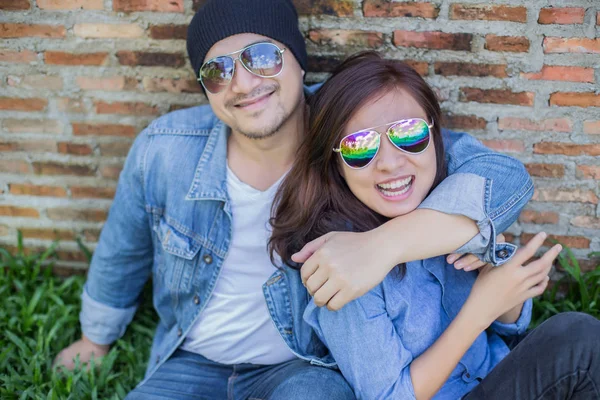 Kız arkadaşı için açık tuğla duvara gitar hipster adam birlikte zevk.