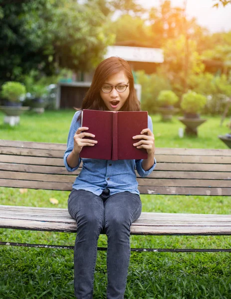 Bir kitap okuma bahçede oturan bir kadın.
