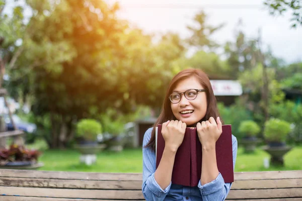 Bir kitap okuma bahçede oturan bir kadın.