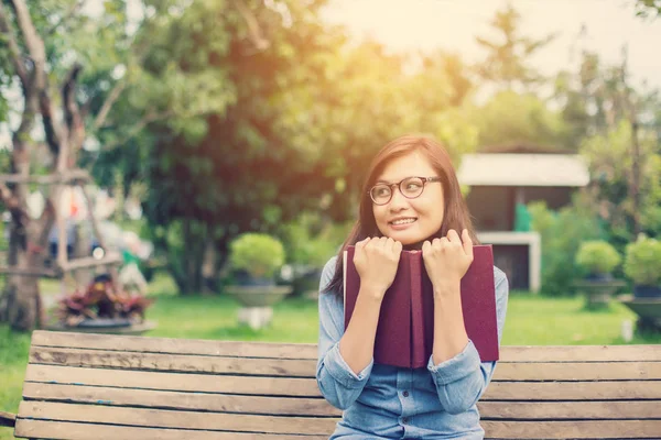 Bir kitap okuma bahçede oturan bir kadın.