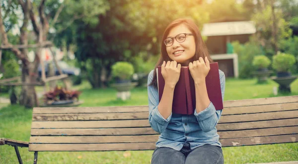 Bir kitap okuma bahçede oturan bir kadın.