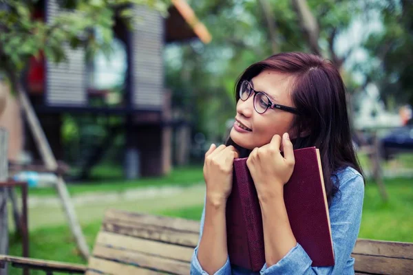 Bir kitap okuma bahçede oturan bir kadın.