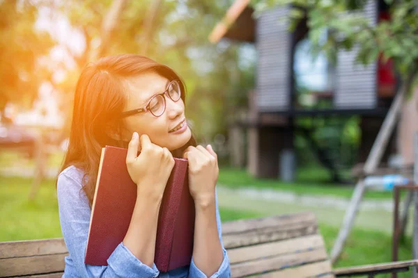 Bir kitap okuma bahçede oturan bir kadın.