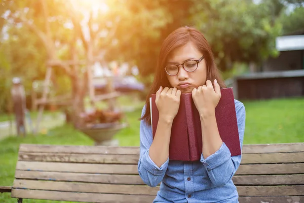 Bir kitap okuma bahçede oturan bir kadın.