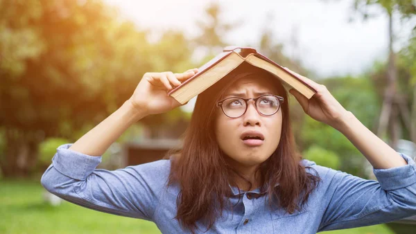 Bir kitap okuma bahçede oturan bir kadın.