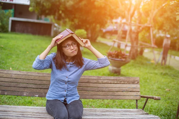 Bir kitap okuma bahçede oturan bir kadın.