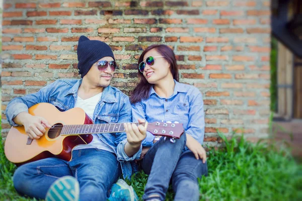 Hipster Uomo Suonare Chitarra Sua Ragazza All Aperto Contro Muro — Foto Stock