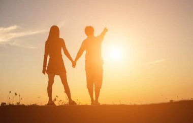  bir adam ve birlikte yürüyen birbirleri ile elele kadın silüeti.